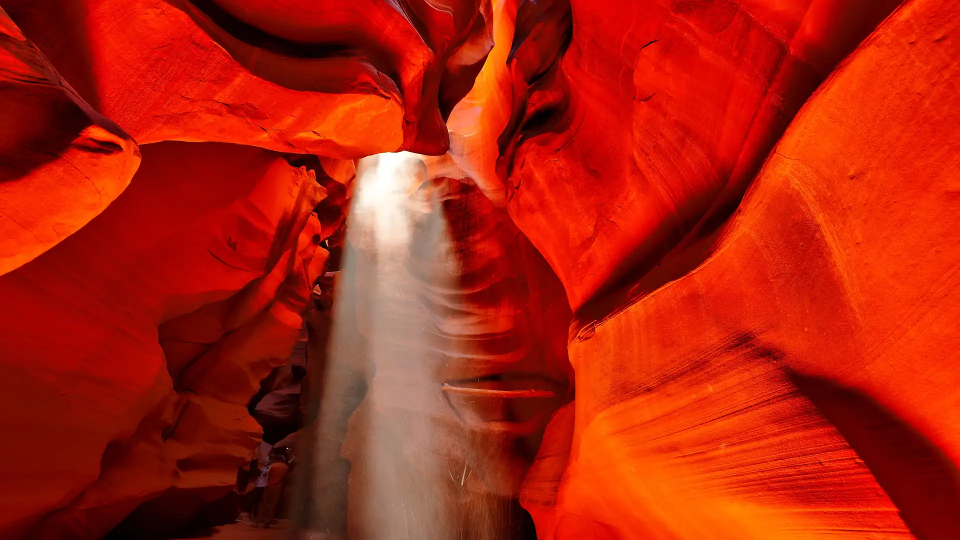 Een zonnestraal die door de gloeiende rode zandsteenmuren van Antelope Canyon valt